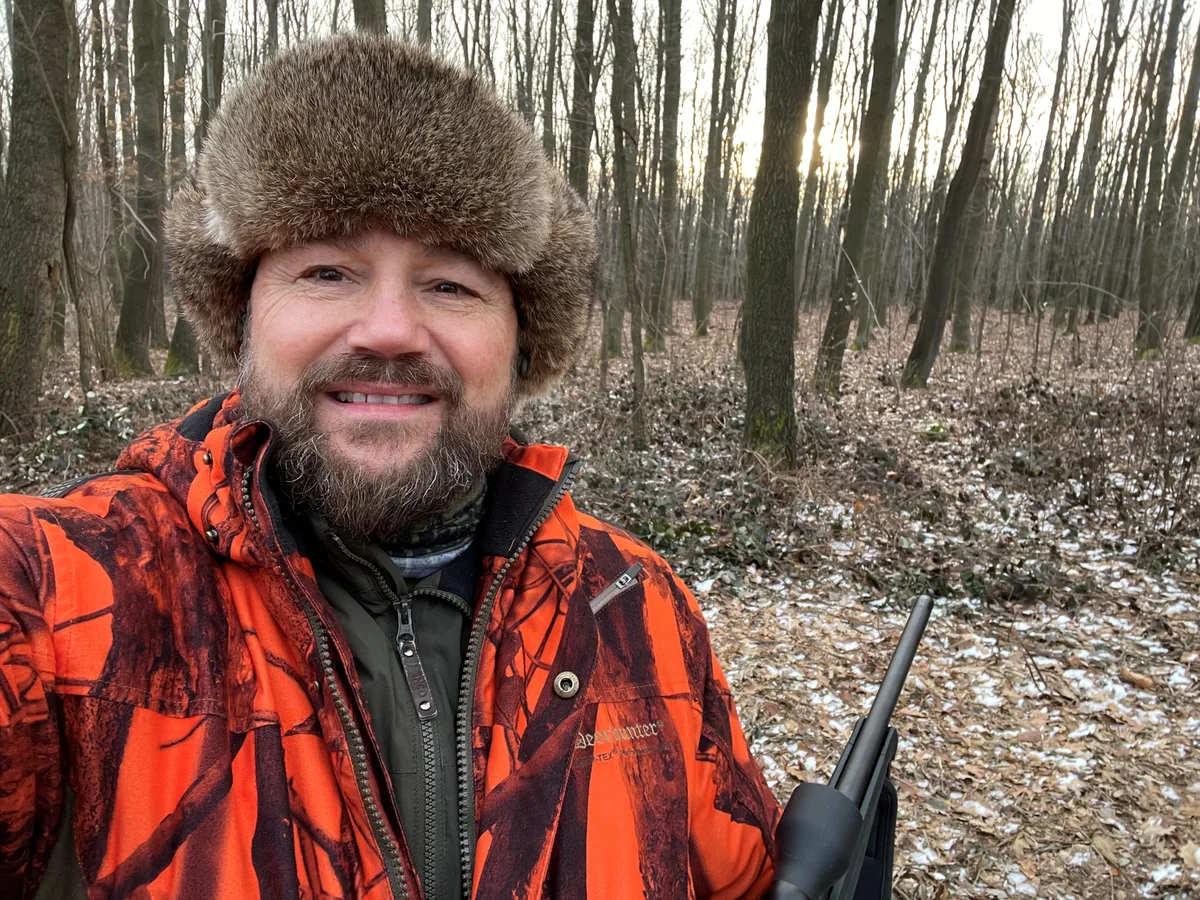 Ein Mann mit Fellmütze und Gewehr.